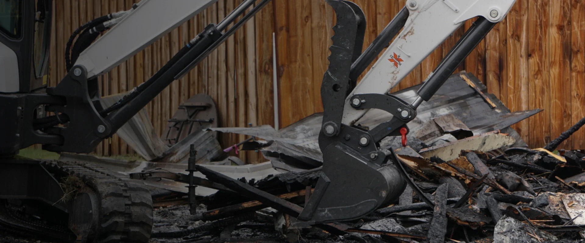 white excavator hauling debris